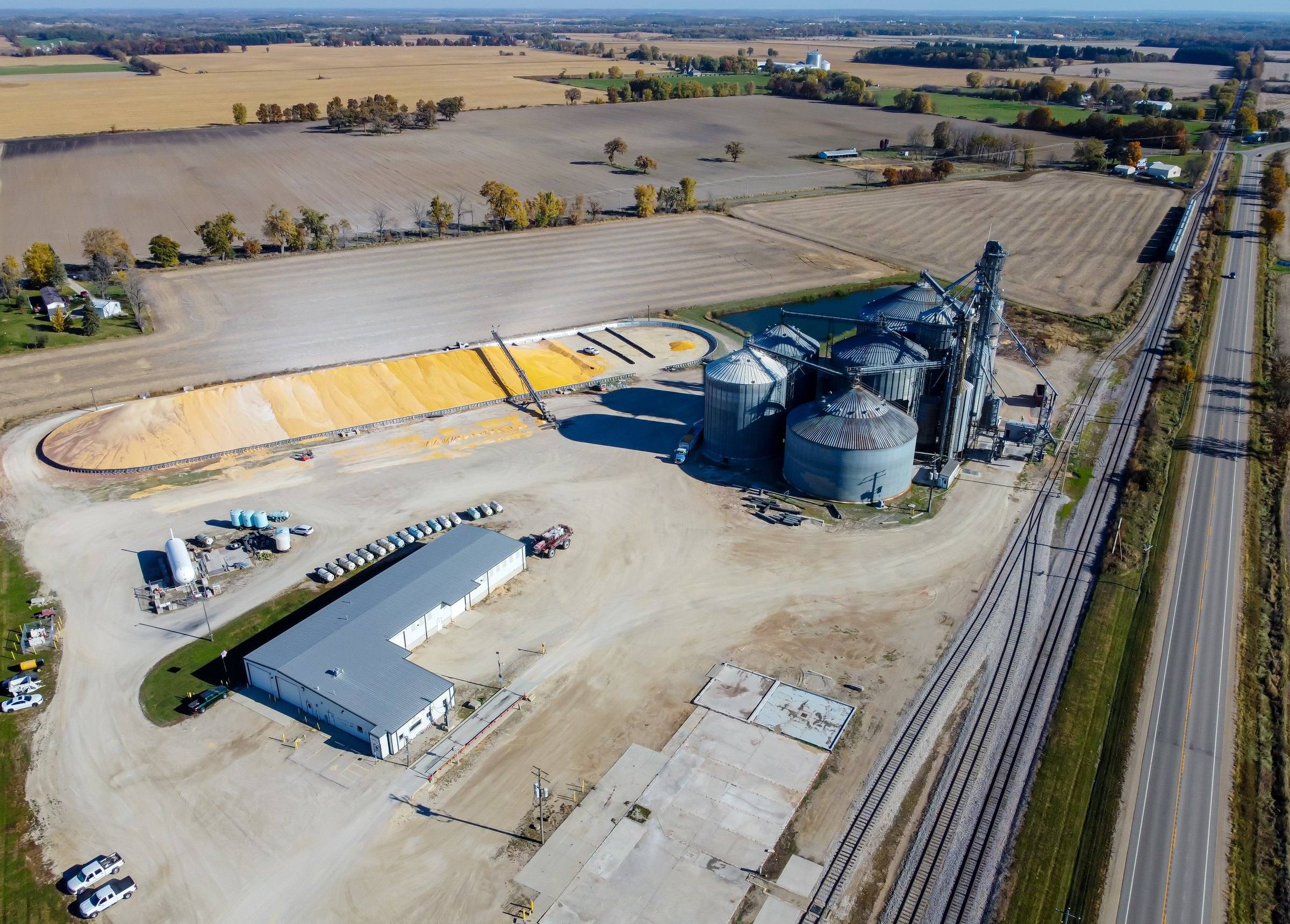 Vista aérea de unidade de armazenagem de grãos com silos e ramal ferroviário